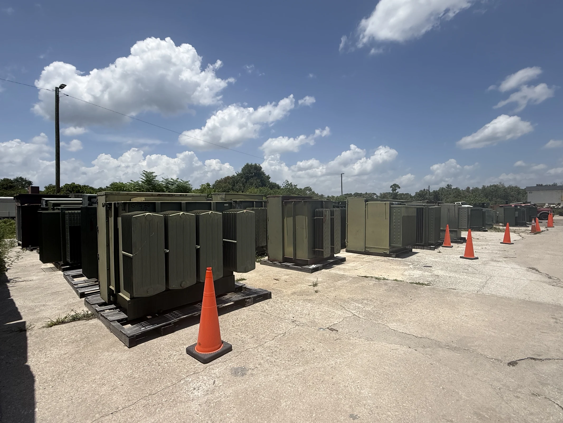 Rows of commercial transformers staged in an industrial equipment yard